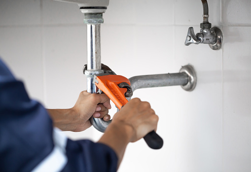 plumber at work in a bathroom, plumbing repair service, assemble and install concept.